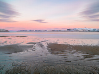 The texture of the sand on the sea beach at low tide at sunset.