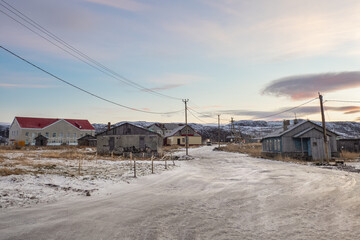 Fototapeta na wymiar Evening mystical view of the old Arctic village with abandoned houses. Teriberka.