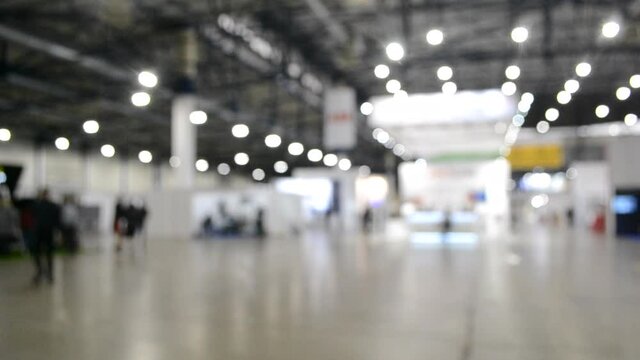 Blurred background. Inside big empty building with high ceiling.