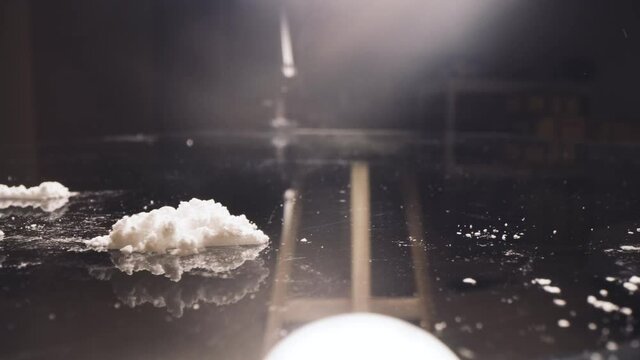 Cocaine junkie snorting line of coke with rolled US dollar bill. Drug Addiction.