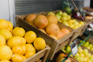 Fresh oranges near fruits on blurred background in supermarket