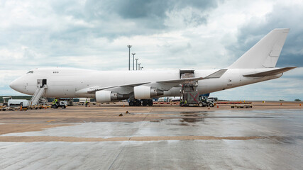 Fototapeta na wymiar White Boeing 747 400 Freighter carrying cargo at cloudy day