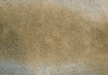 Fototapeta na wymiar finely structured beige surface with small tufts of sand