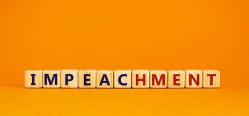 Impeachment symbol. Wooden cubes with the word 'impeachment'. Beautiful orange background, copy space. Business, impeachment concept.