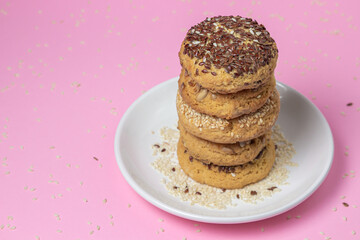 Shortbread cookies on a pink background. Shortbread cookies with sprinkles on a white plate. Light dessert