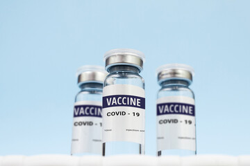Three cans of coronavirus vaccine. on a blue background. copy space, banner