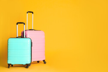 Travel suitcases on yellow background, space for text. Summer vacation