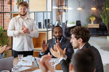 Clapping hands. Diverse group of co-workers having casual discussion in office. Executives during friendly discussion, month reporting, creative meeting. Concept of business, finance, occupation, job.