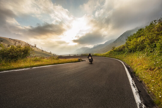Motorcycle driver riding in Alpine route in Europe.