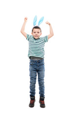Excited young kid with Easter bunny ears jumping with raised hands looks at camera. Full length...