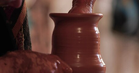 Potters wheel, hands forms clay pot on potter's wheel