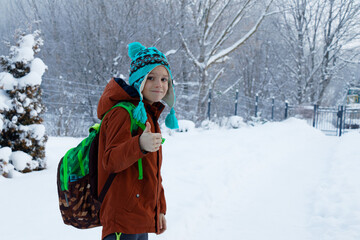 View on a child from behind with a school bag on the way to school in winter