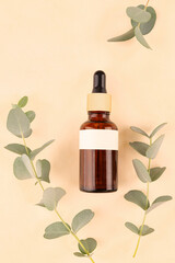 A bottle of essential oil with fresh eucalyptus leaves.