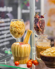 Dried vegetables in glass jars, onions, beets, carrots, pumpkin, bay leaf, banks on straw napkin and wooden background. Superfoods, herbs.