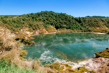 Fototapeta na wymiar Green crater lake with rising steam in Waimangu Volcanic Valley