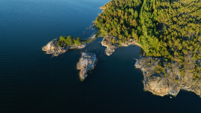Top down view of rocky island in Saaristomeri. The Archipelago in summer. Beautiful island and pine forest. Drone photo from above. Nordic Nature. Finland.
