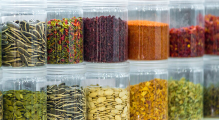 Dried vegetables in glass jars, onions, beets, carrots, pumpkin, bay leaf, banks on blurred background. Superfoods, herbs.