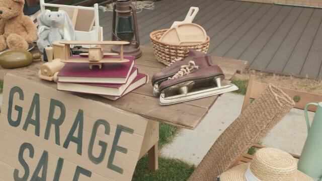  Handheld tracking of old clothes, toys, books and other items at garage sale in suburban neighborhood