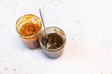 Two jars of homemade jams, one with apricot and the other with figs