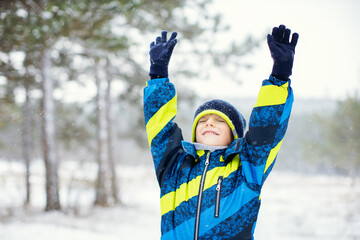 Portrait of a little cute boy outdoor in winter forest.