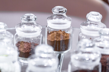 Regular and alkalised cocoa powder on with dar chocolate, in glass jars with lids.