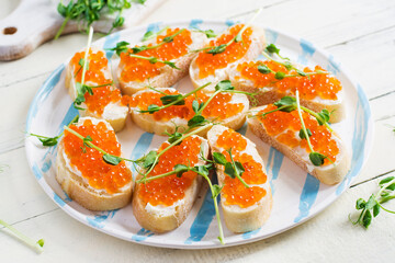 Canape with salmon red caviar. Sandwich for lunch. Delicious food.