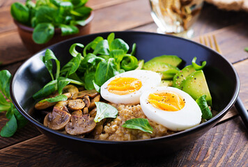 Breakfast oatmeal porridge with boiled egg, avocado and fried mushrooms. Healthy balanced food.