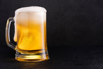 Cold beer with foam on black backgound