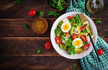 Fresh avocado salad with tomato, avocado, boiled eggs and fresh lettuce. Ketogenic diet breakfast.  Keto, paleo salad. Top view, overhead, above