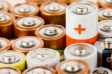 Isolated old battery leakage, hazardous waste concept. Energy abstract background of colorful batteries.
