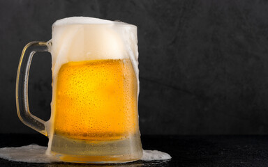 Cold beer with foam on black backgound	