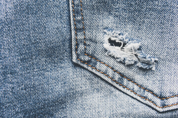 Denim blue jeans texture with scuffs and holes. Abstract background.