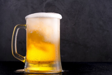 Cold beer with foam on black backgound	