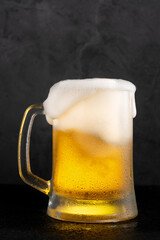 Cold beer with foam on black backgound