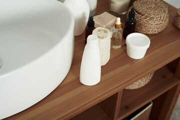 Body care cosmetics with accessories near sink in bathroom