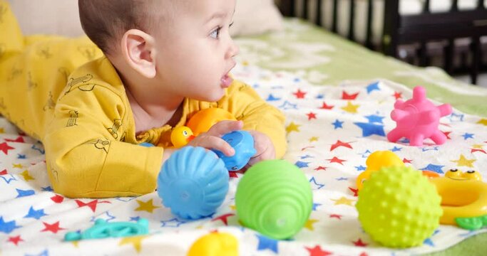 infant, childhood concept - close-up of smiling happy Baby plays with a teether. Teeth cutting. First teeth. Joy toothless 7 months baby bite, gnaws teether toy