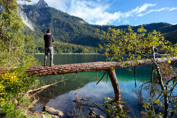 A person looking across a clear alpine lake on a sunny day in Germany