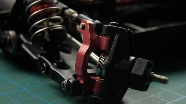Close-up of radio control model suspension elements buggy car on cutting mat