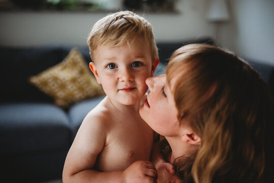 Close up of a blonde mother and son hugging and kissing at home