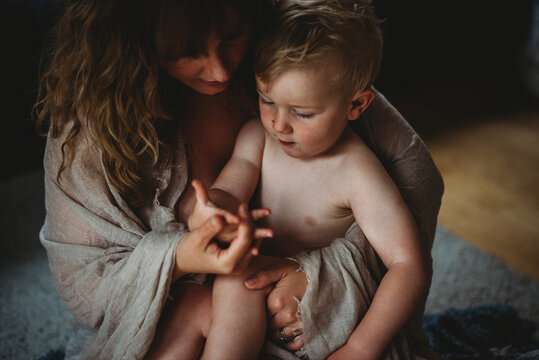 Mom holding sons hand showing lots of skin intimate at home
