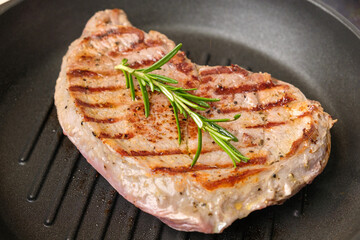 Fried beef steak in the grill pan with rosemary. Healthy dinner concept. 