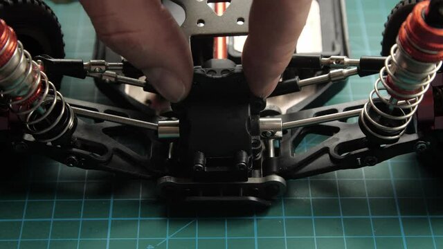 Close-up radio control model buggy car. The hands of the master assemble the differential