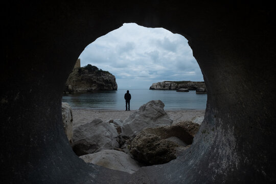 Man standing by the sea seen through a hole