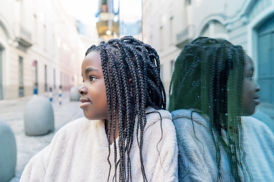beautiful african girl with braids on glass wall