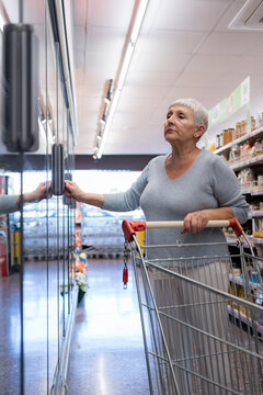 Caucasian elderly woman with white hair  shopping in supermarket