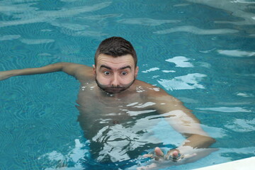 Terrified man asking for help in swimming pool 