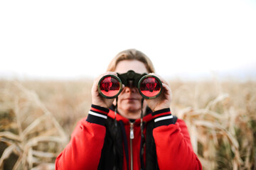 woman holding binoculars at farm