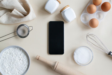 Online cooking courses. The smartphone lies at the center of the ingredients for a meal. Top view. Copy space.