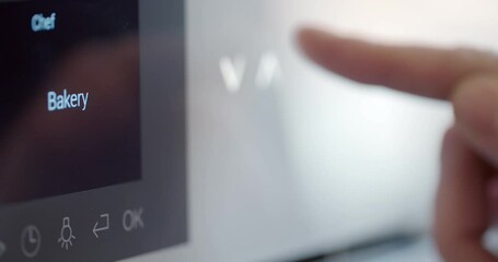 Close up female hand using microwave for cooking dinner in kitchen