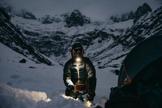 Man Making Tea Close to the Tent in Switzerland Mountains Winter